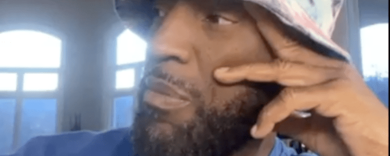 Man wearing hat, thoughtful expression, indoors.